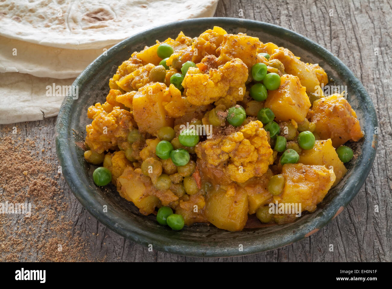 Le chou-fleur et de pommes de terre sur une table en bois curry servi avec chapattis. Banque D'Images