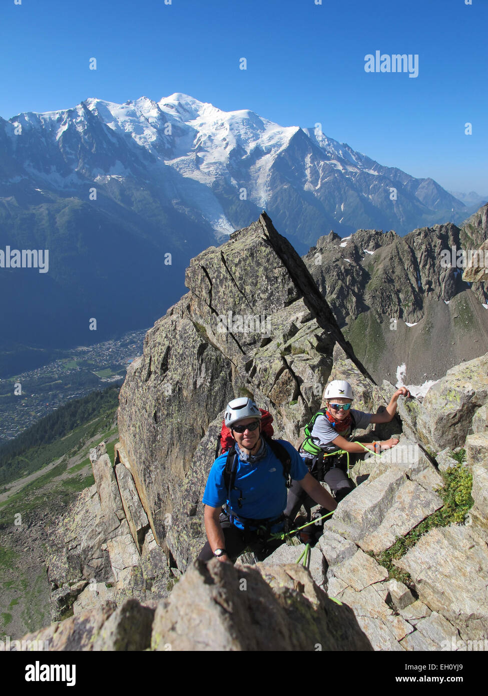 Garçon et père de l'escalade sur une journée ensoleillée dans les Alpes. Le Mont Blanc est à l'arrière-plan. Banque D'Images