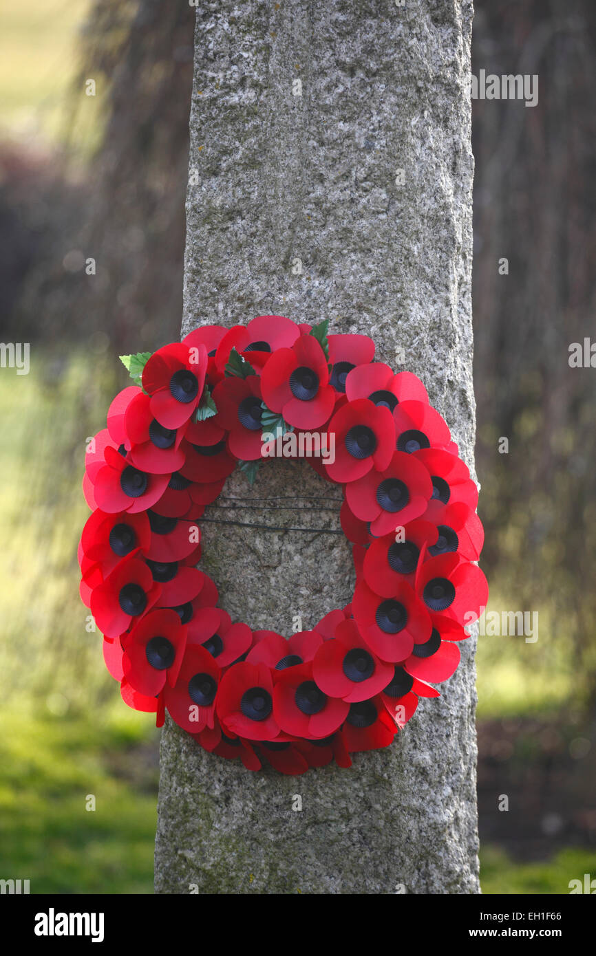 Guirlande de pavots du souvenir sur un monument de guerre dans Fring, Norfolk. Banque D'Images