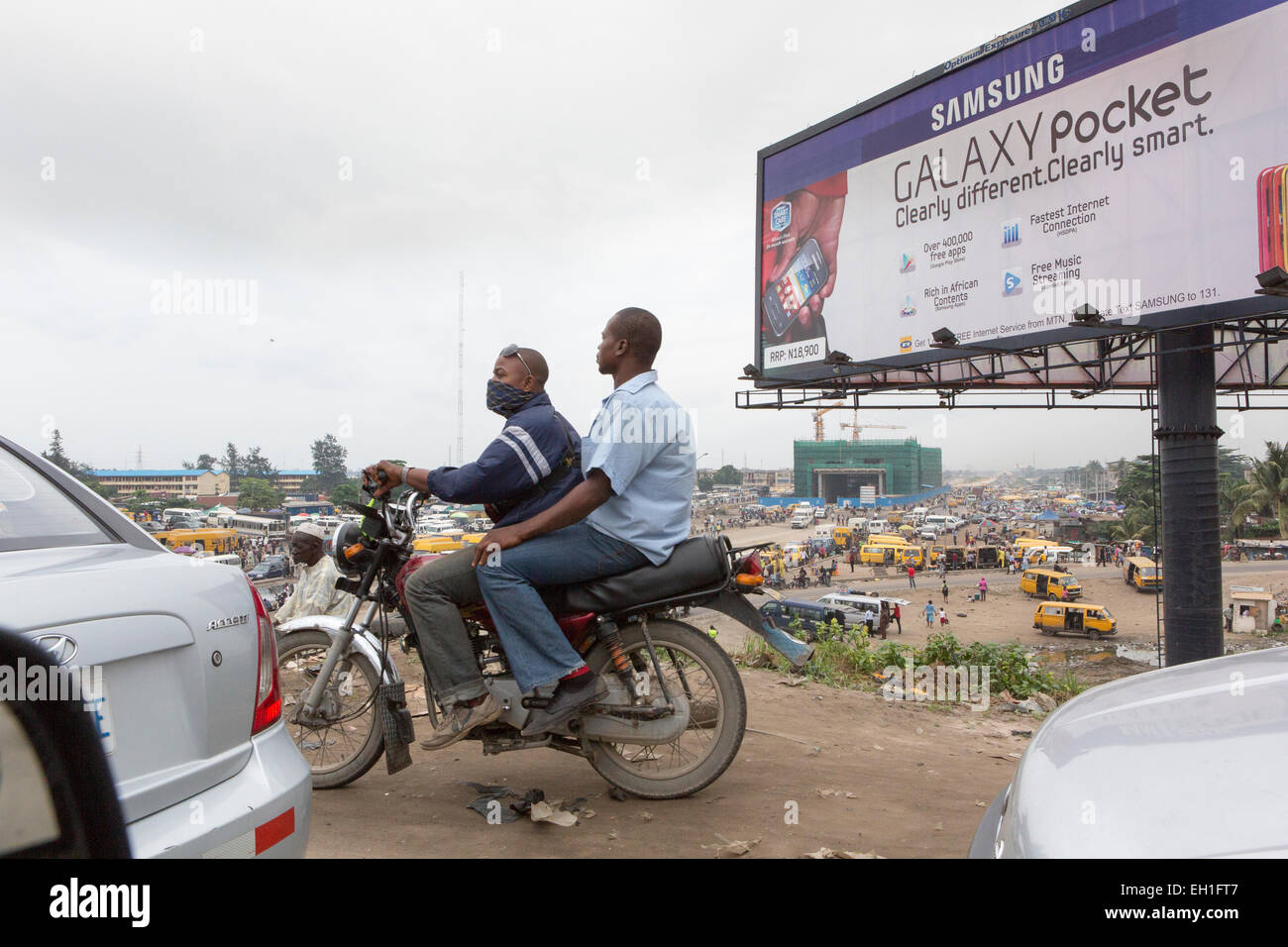 Lagos, Nigéria ; les gens sur une moto dans la circulation intense. Banque D'Images