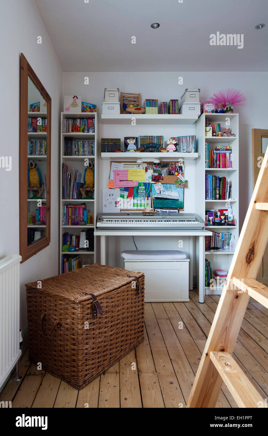 Bibliothèque et panier à linge dans la chambre de l'enfant de la maison de Macclesfield, Cheshire, England, UK Banque D'Images