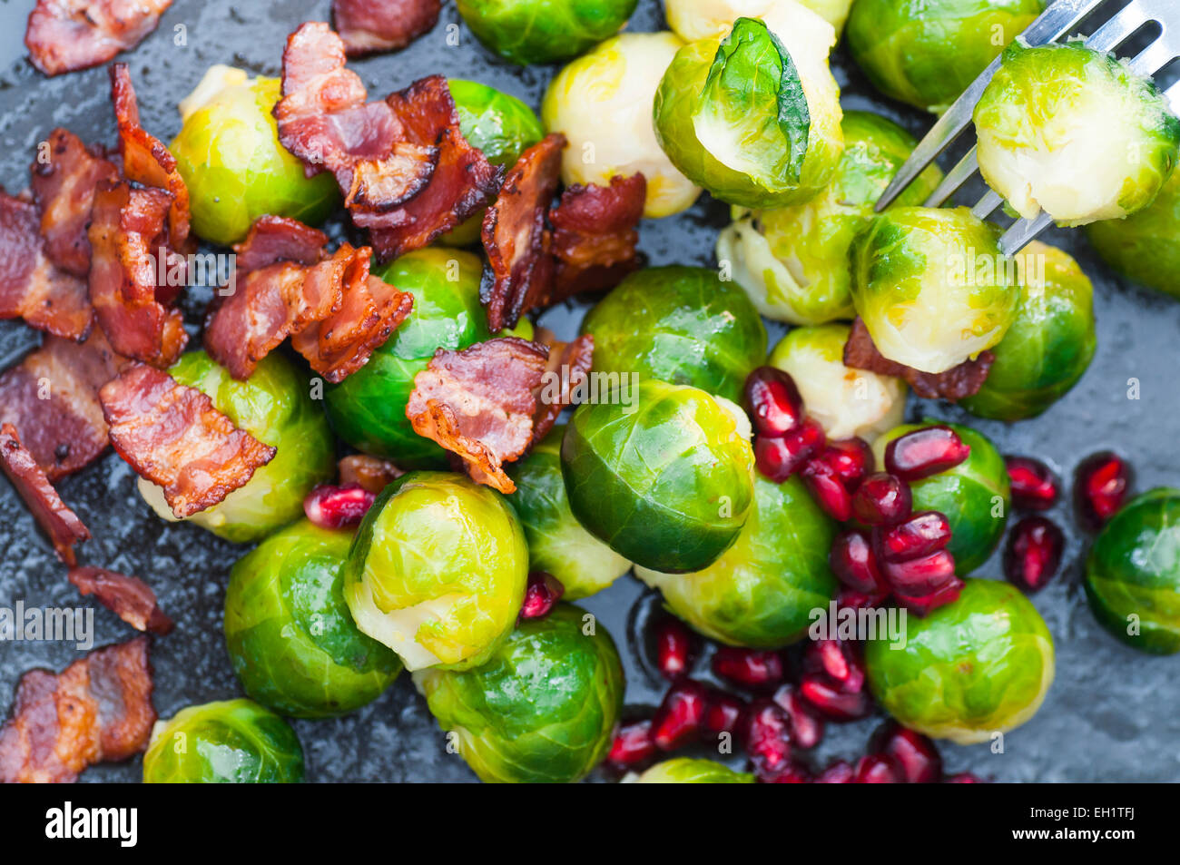 Embeurrée de choux de Bruxelles au bacon et la grenade. Banque D'Images