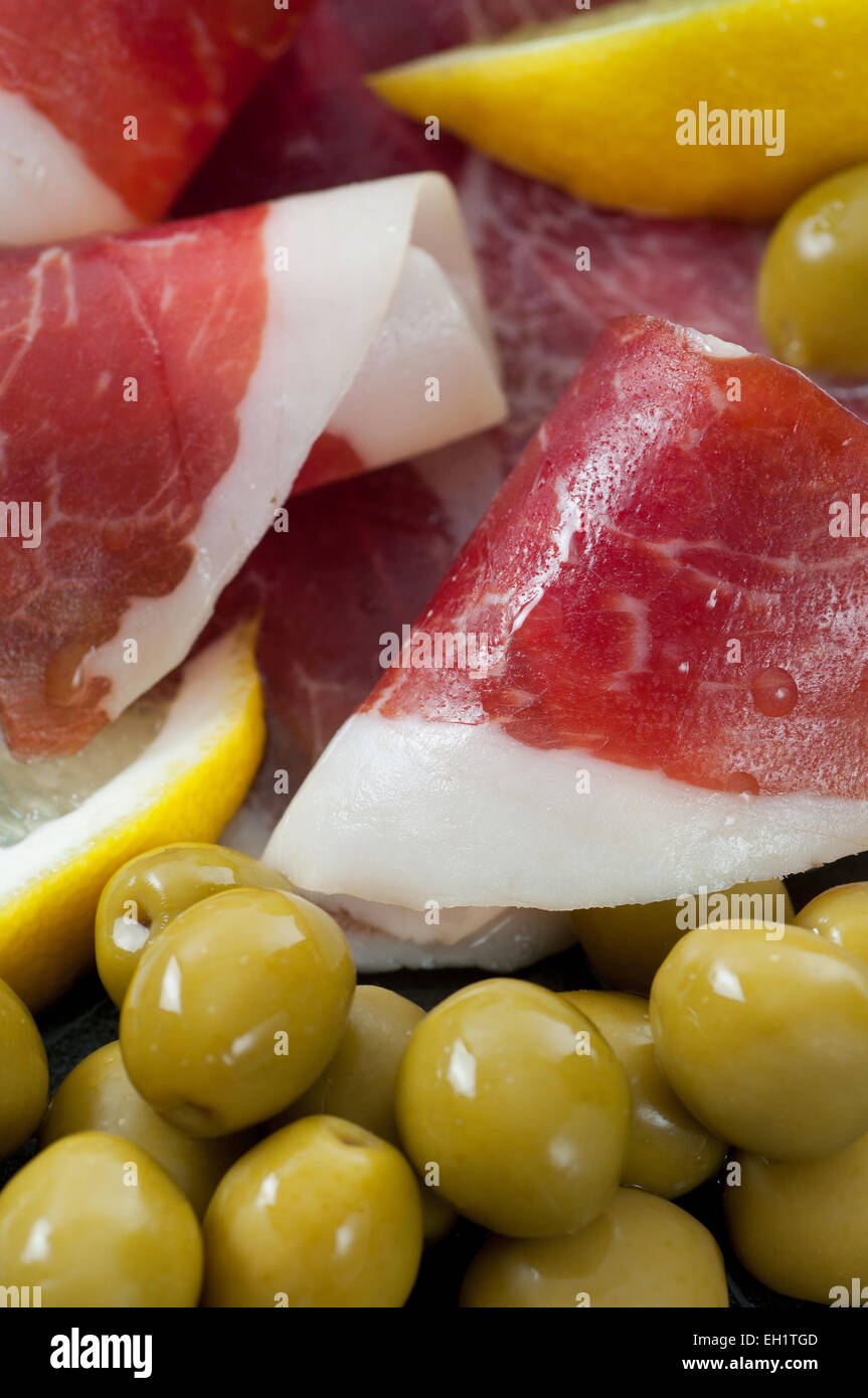 Tranches de prosciutto aux olives vertes et citron. Banque D'Images