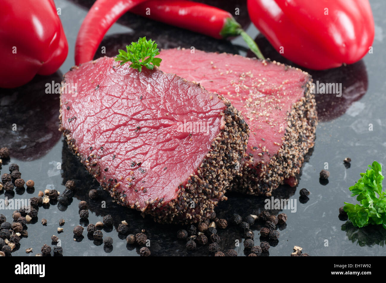 Deux steaks au poivre garni de persil et de poivre noir. Banque D'Images