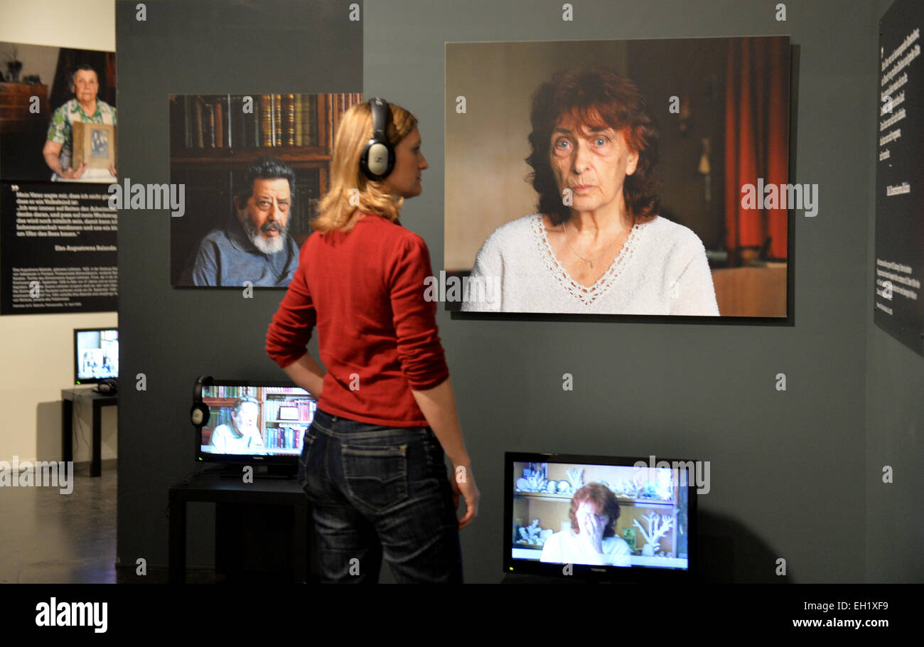 Un visiteur à l'écoute d'une entrevue avec Nelli Konstantinowa Kalinina, dont le père, le concepteur d'avions Kalinin, a été exécuté le 22 octobre 1938, dans le cadre d'une exposition à la maison de l'histoire de Brandebourg-prusse à Potsdam, Allemagne, 05 mars 2015. L'exposition 'Les grandes purges de 1937-1938 dans l'Union soviétique", ce qui est illustré en Allemagne pour la première fois, présente 80 reproductions de photographies prison agrandie, ainsi que 200 projections audiovisuelles et des entrevues vidéo avec des témoins oculaires. PHOTO : BERND SETTNIK/dpa Banque D'Images