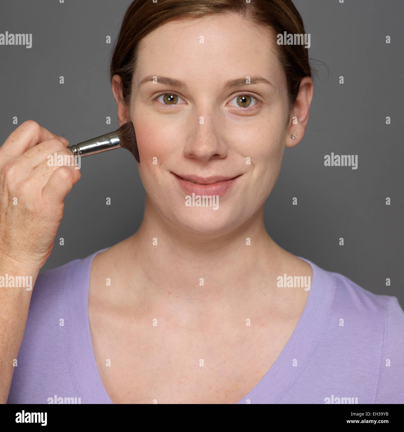 Close-up of Woman having Blush appliqué, Studio Shot Banque D'Images