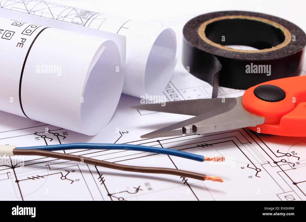 Coupe-câbles, fils électriques, ruban isolant noir, rouleaux de schémas  électriques sur plan de construction de maison Photo Stock - Alamy