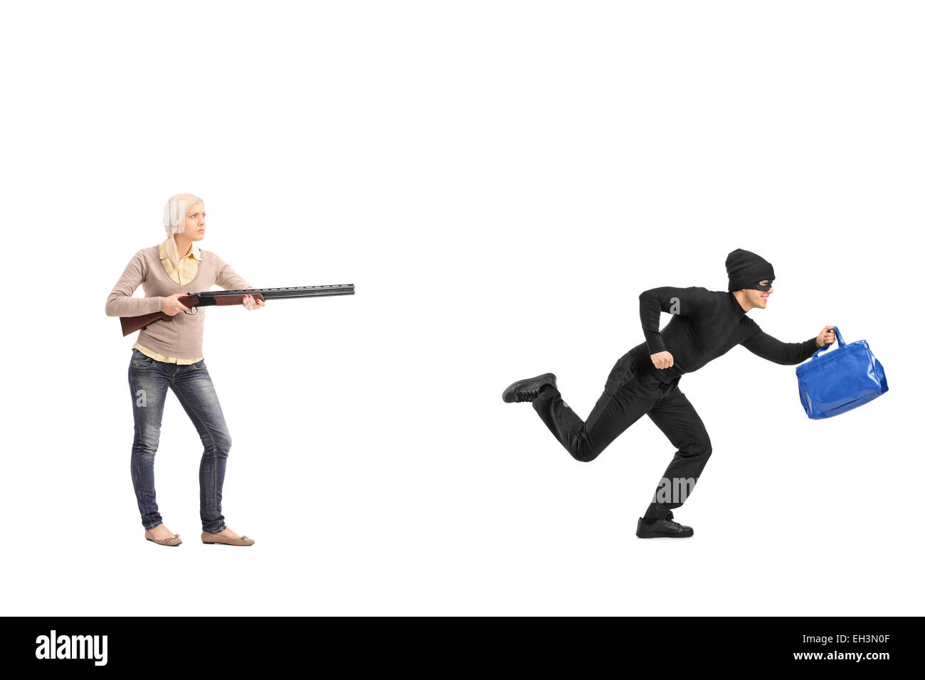 Portrait d'une femme en colère chassant un cambrioleur avec un fusil isolé sur fond blanc Banque D'Images