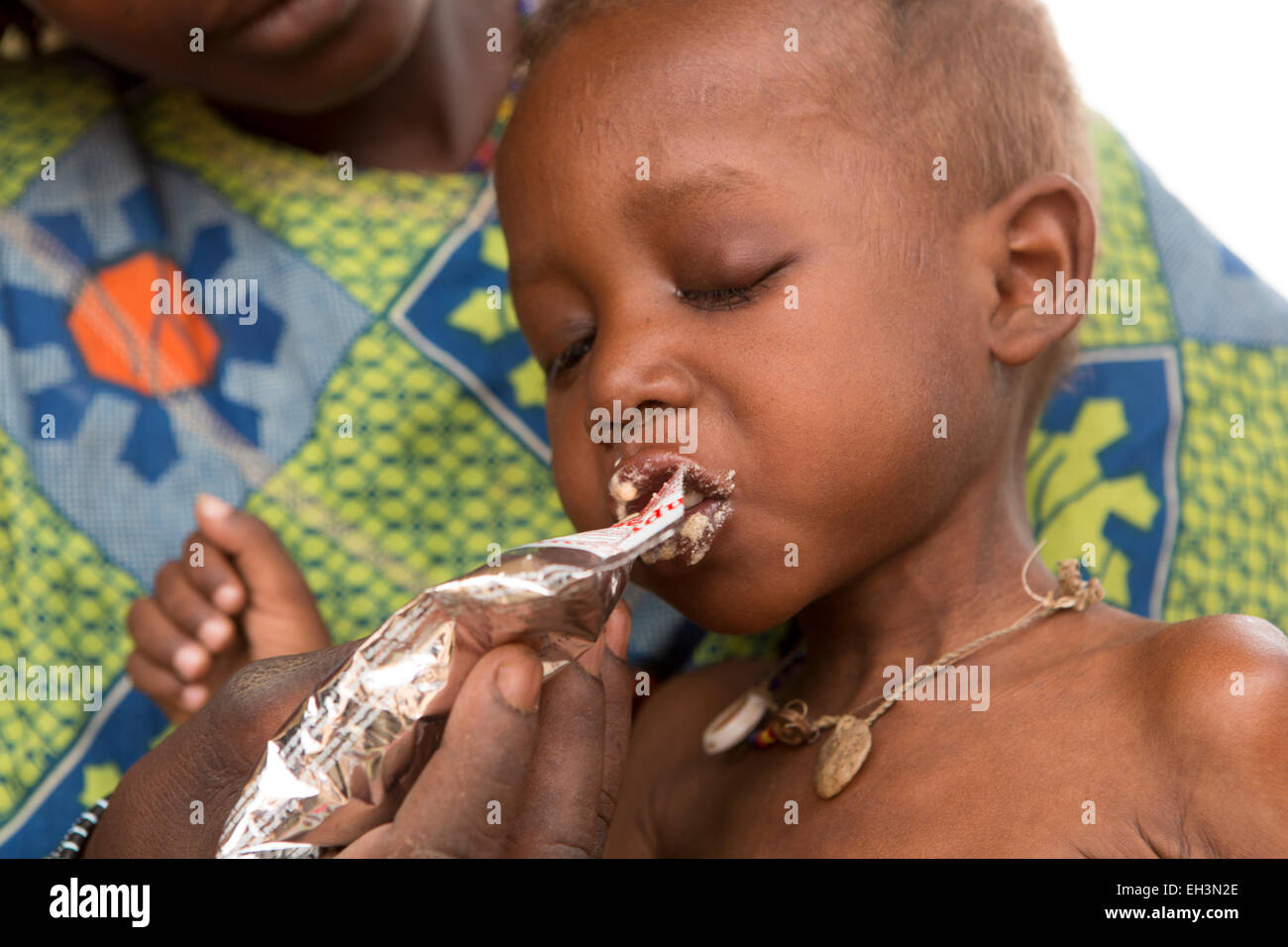 KOMOBANGAU, PROVINCE DE TILLABERI, NIGER, 15 mai 2012 : Fatimata Birma, et son fils de deux ans, sont traités à la clinique de santé pour les malnutition. Soumaila mange Plumpy Nut. Banque D'Images