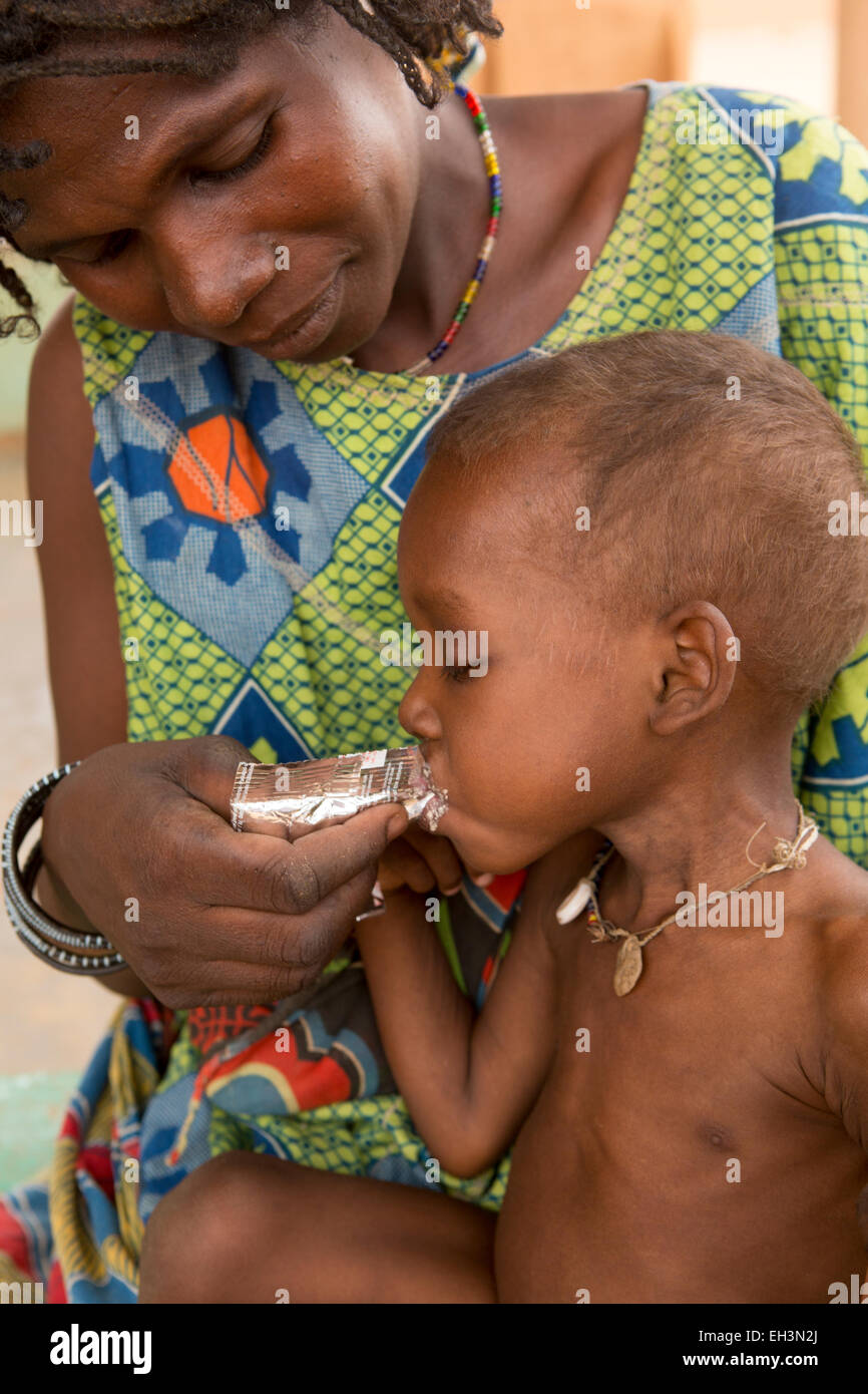 KOMOBANGAU, PROVINCE DE TILLABERI, NIGER, 15 mai 2012 : Fatimata Birma, et son fils de deux ans, sont traités à la clinique de santé pour les malnutition. Soumaila mange Plumpy Nut. Banque D'Images