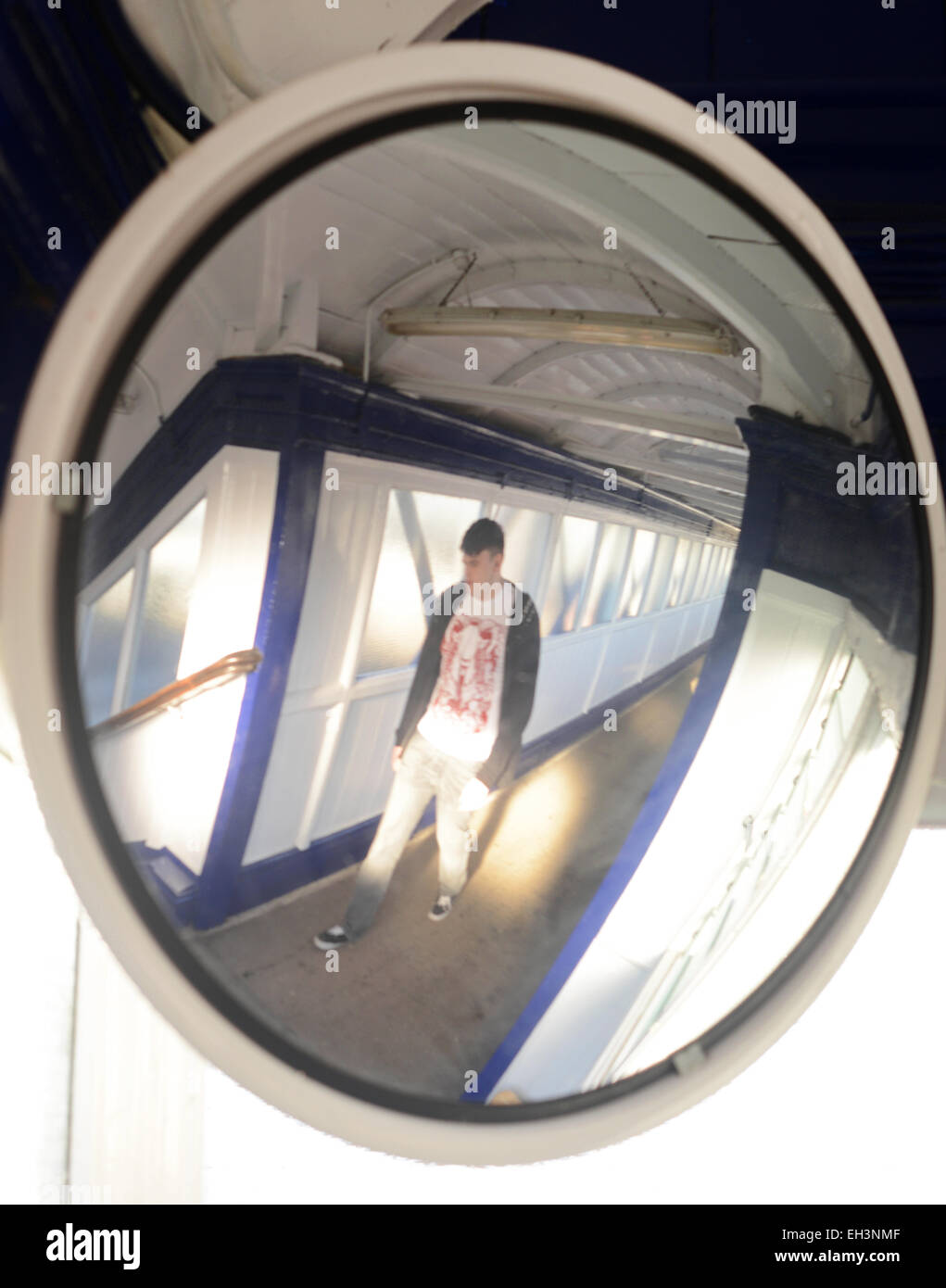 Homme marchant passé convex mirror sécurité étapes ci-dessus sur un passage pour piétons à la gare selby Royaume-Uni Banque D'Images