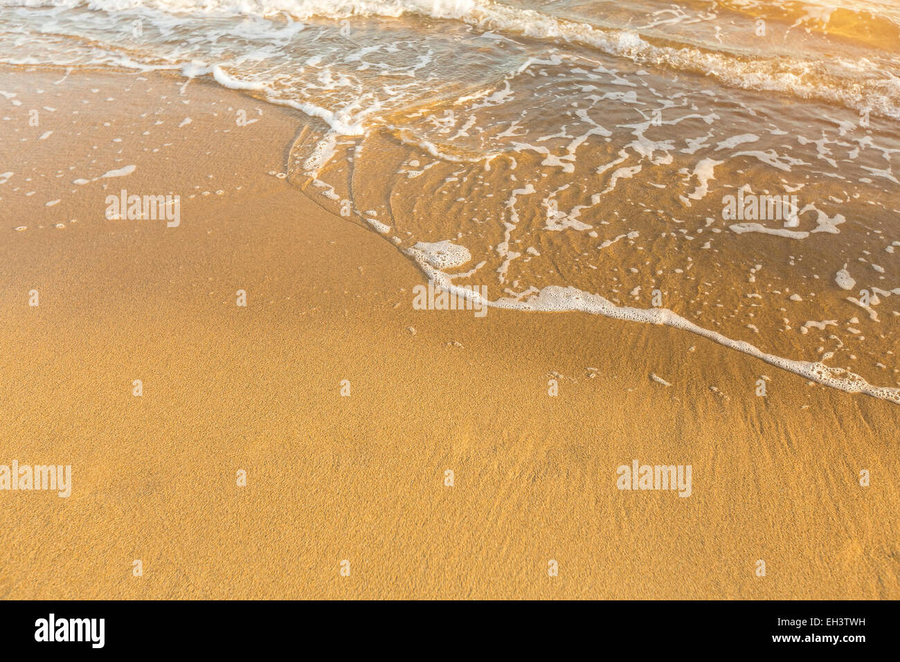 Vague douce sur la plage et la texture de la mer de sable doré. Banque D'Images