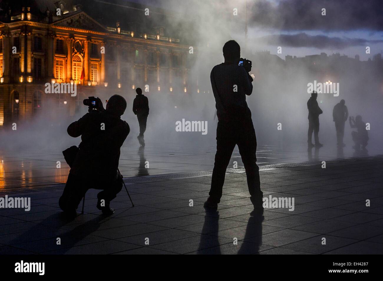 France, Gironde, Bordeaux, zone classée au Patrimoine Mondial de l'UNESCO, Marechal Lyautey Gate, Place de la Bourse, le port de la Lune, des groupes de jeunes sur une esplanade d'un plan d'eau à l'obscurité Banque D'Images