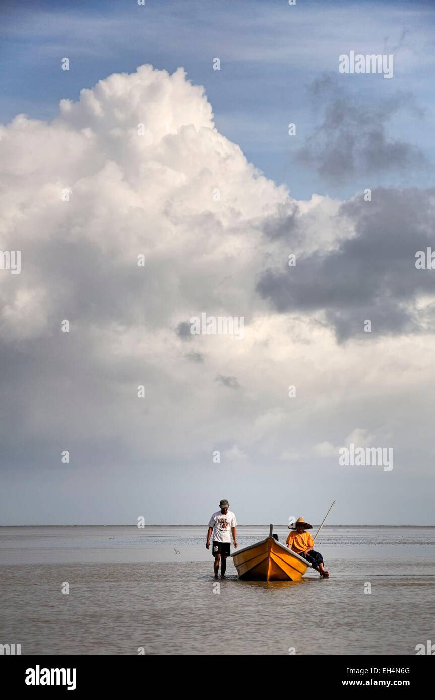 La Malaisie, Bornéo, Sarawak, parc national de Bako, pêcheurs sur un bateau sur la mer de Chine du Sud, à marée basse, ciel nuageux Banque D'Images