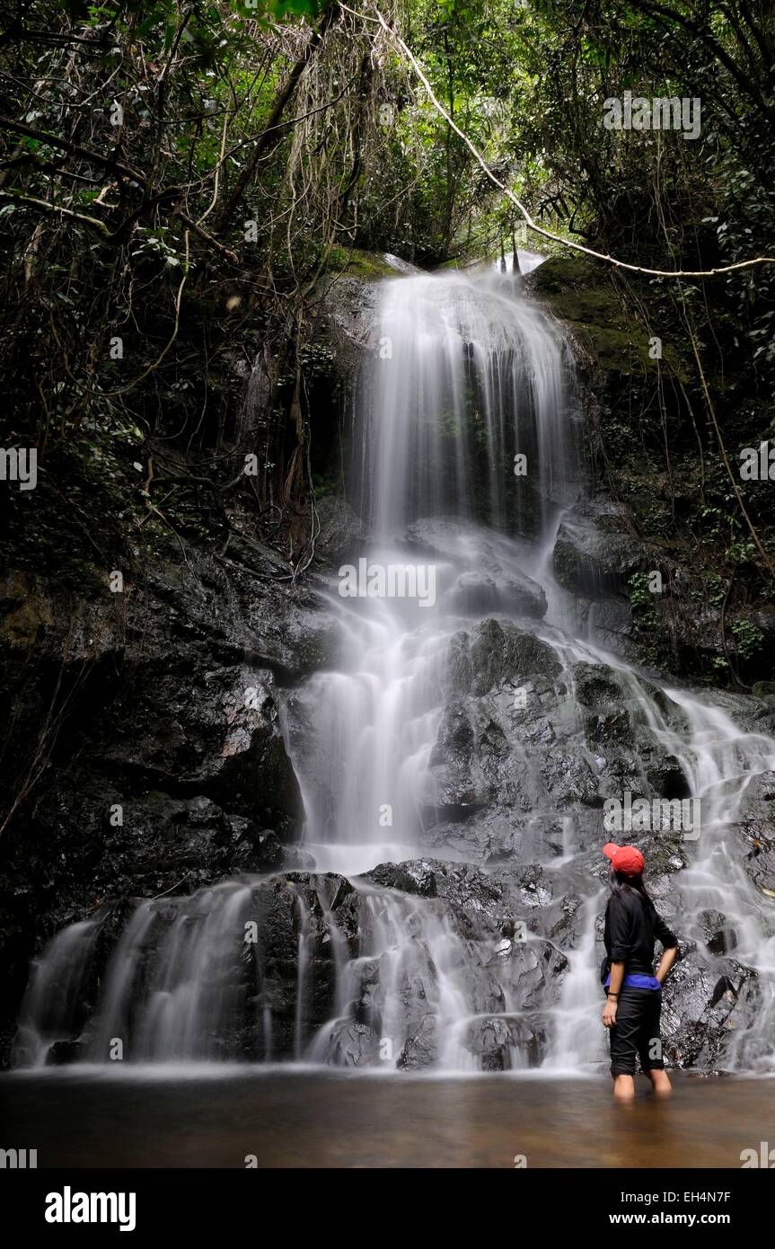 L'Ouest de Sumatra, Indonésie, Minangkabau Highlands, région Bukittinggi, Harau valley, femme près d'une chute dans la forêt Banque D'Images