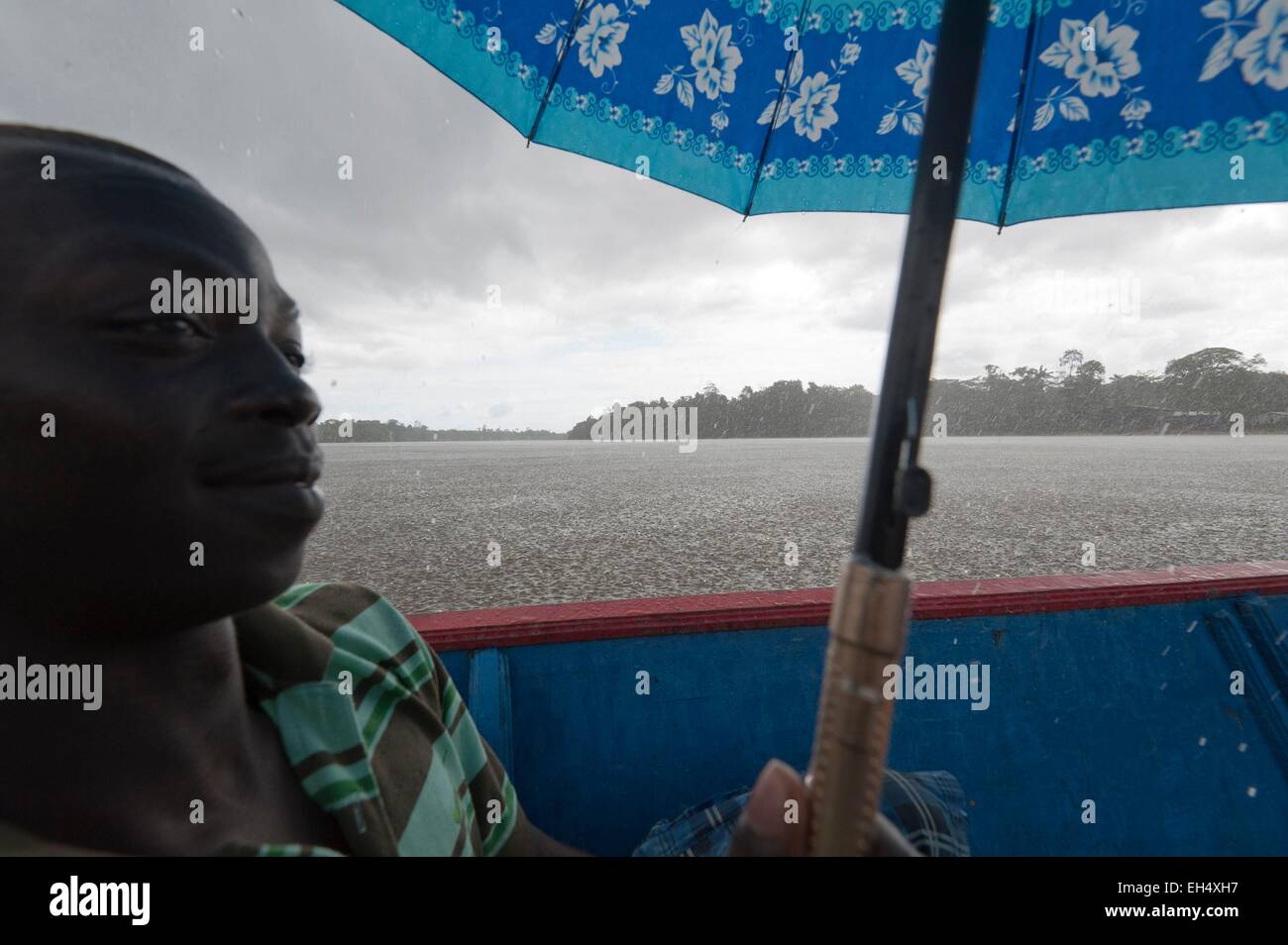 France, Guyane, Parc amazonien de Guyane (Parc amazonien de la Guyane), Grand Santi, un homme dans une pirogue tenant un parapluie, tempête tropicale sur la rivière Lawa devenir en aval du fleuve Maroni Banque D'Images