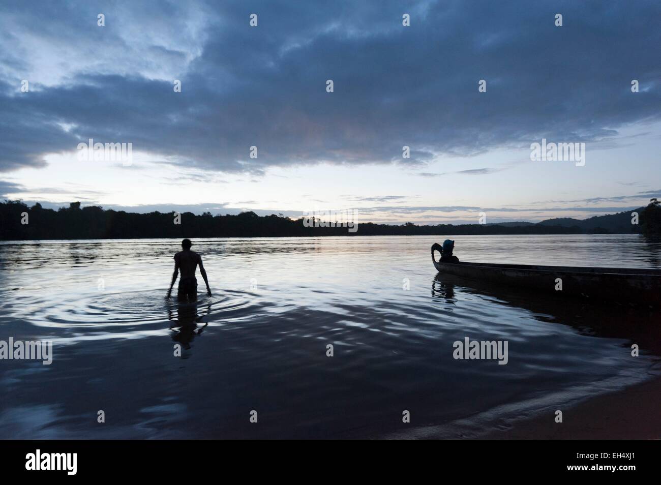France, Guyane, Parc amazonien de Guyane (Parc amazonien de la Guyane), la Providence, l'homme lavant dans le fleuve Maroni au crépuscule Banque D'Images