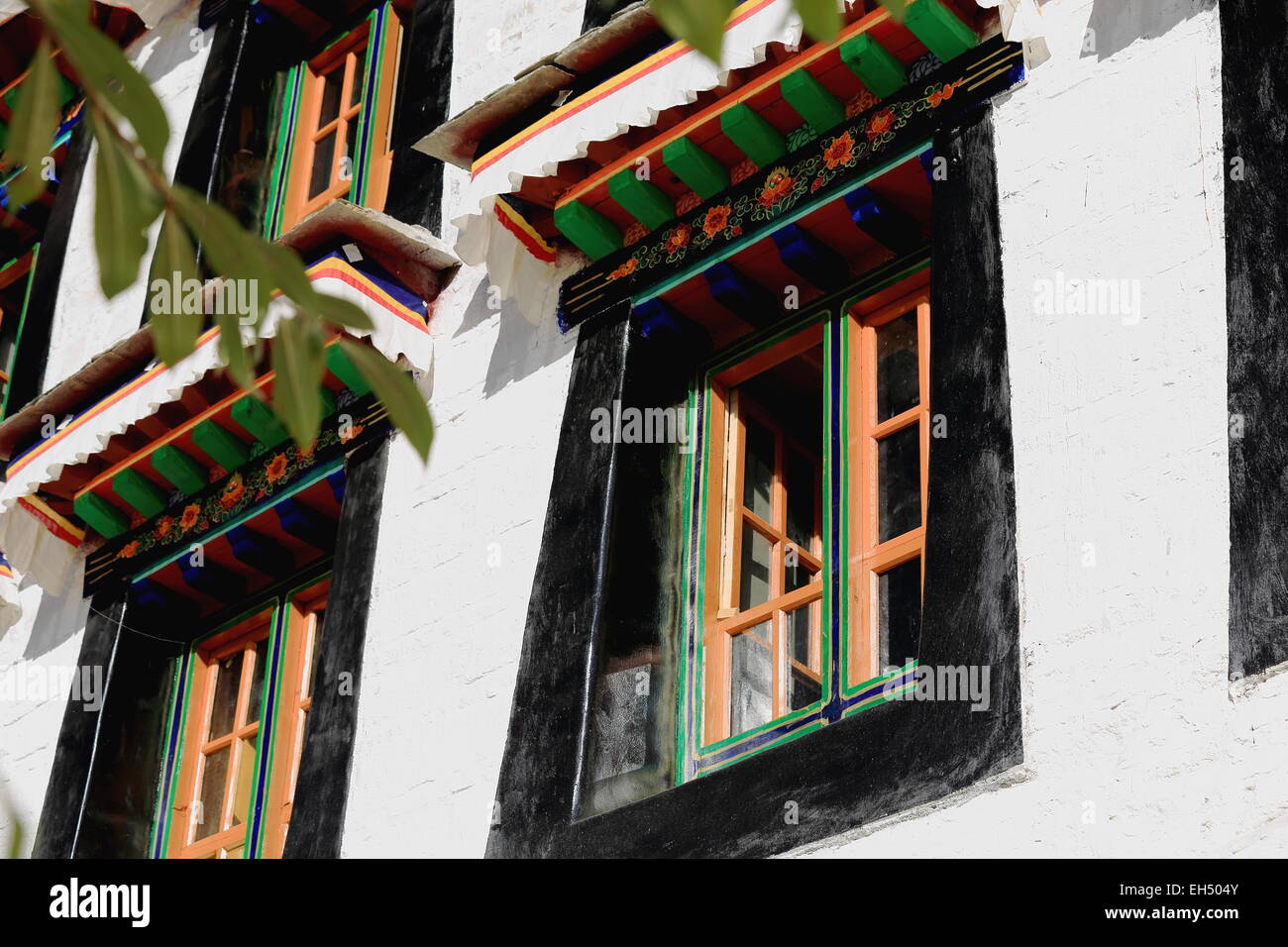 Fenêtres en bois sur le coloriste des murs blancs de l'Drepung-Rice Gelugpa-Yellow monastère bouddhiste de tas de Hat l'ordre. Tibet Banque D'Images