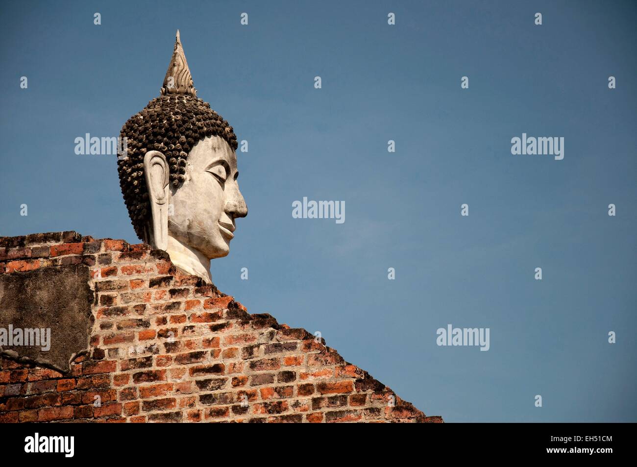 La Thaïlande, Ayutthaya, inscrite au Patrimoine Mondial de l'UNESCO, Wat Yai Chai Mongkol, chef d'une statue de Bouddha en pierre et un mur de brique rouge Banque D'Images