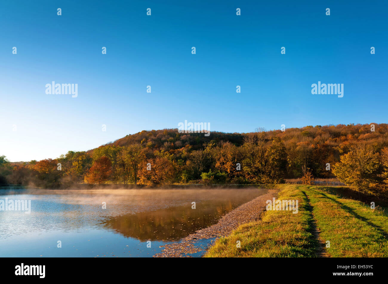 Lever du soleil dans une chute sur un lac avec des arbres et le chemin Banque D'Images