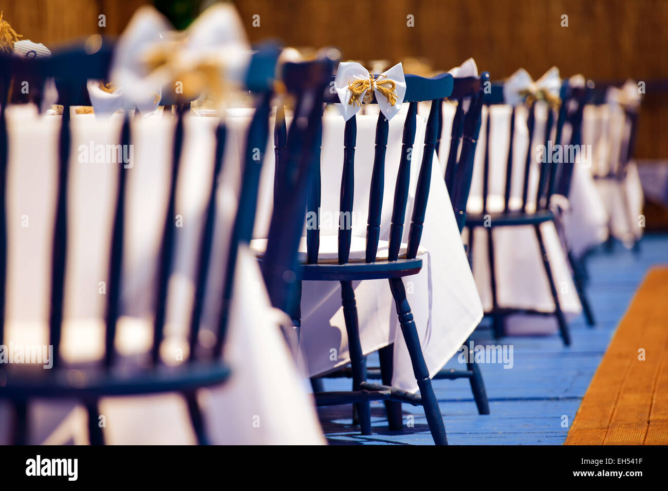 Chaises en bois bleu avec arc blanc au cours de jour de mariage Banque D'Images