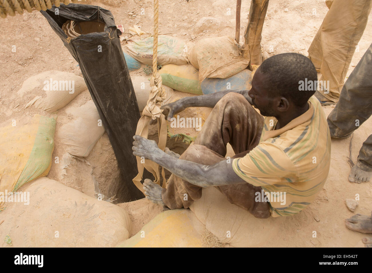 KOMOBANGAU, NIGER, : un mineur met sur une sangle pour être abaissée vers le bas l'entrée de l'arbre d'une mine d'or. Banque D'Images