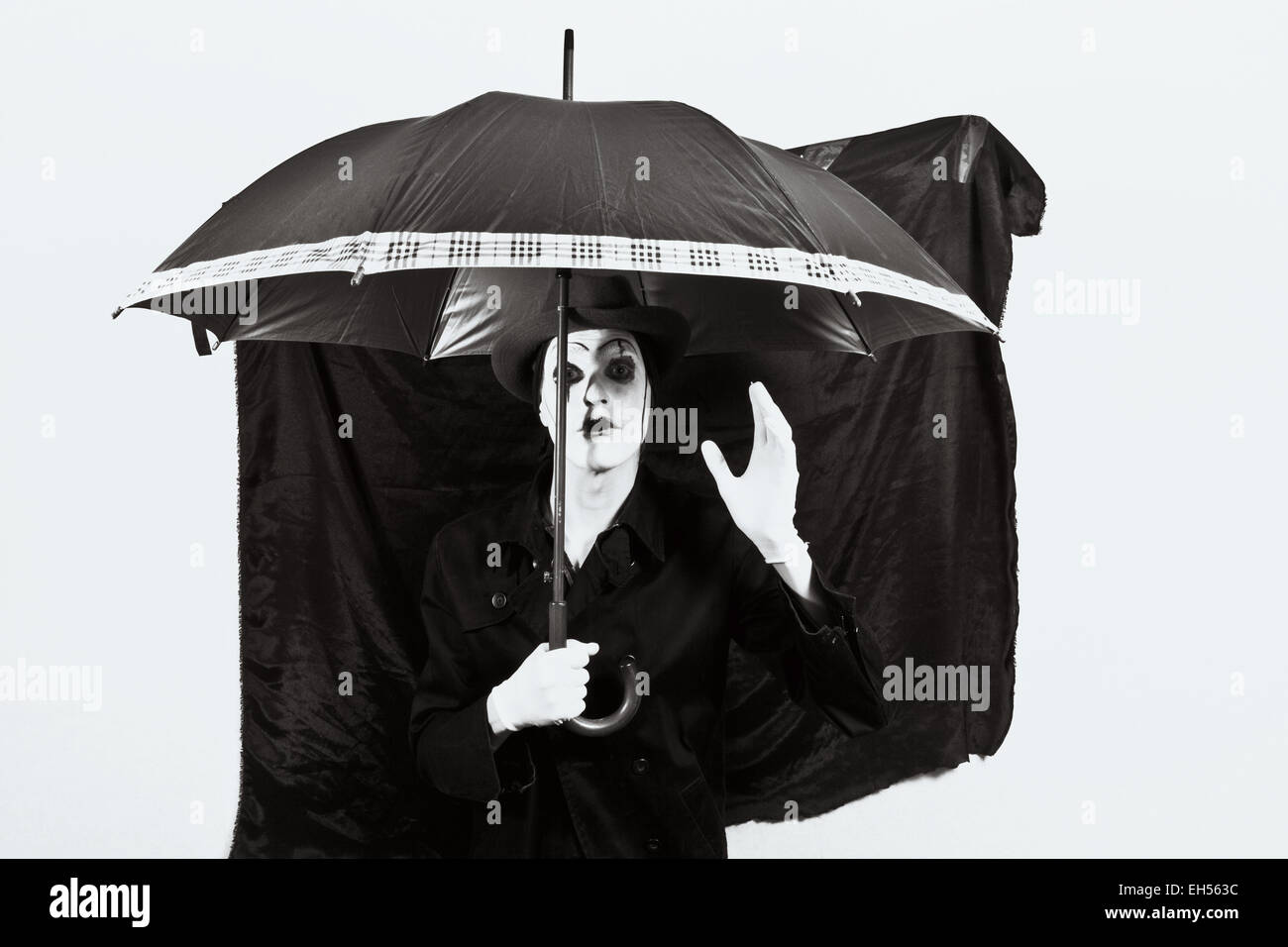 D'un acteur avec le maquillage mime dans un chapeau tenant un parapluie à la main Banque D'Images