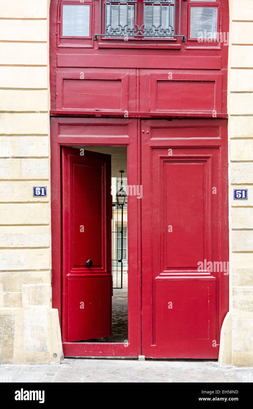 Une porte rouge vif dans le marais s'est établie au fil du temps, laissant  l'étage supérieur légèrement en biais, Paris Photo Stock - Alamy