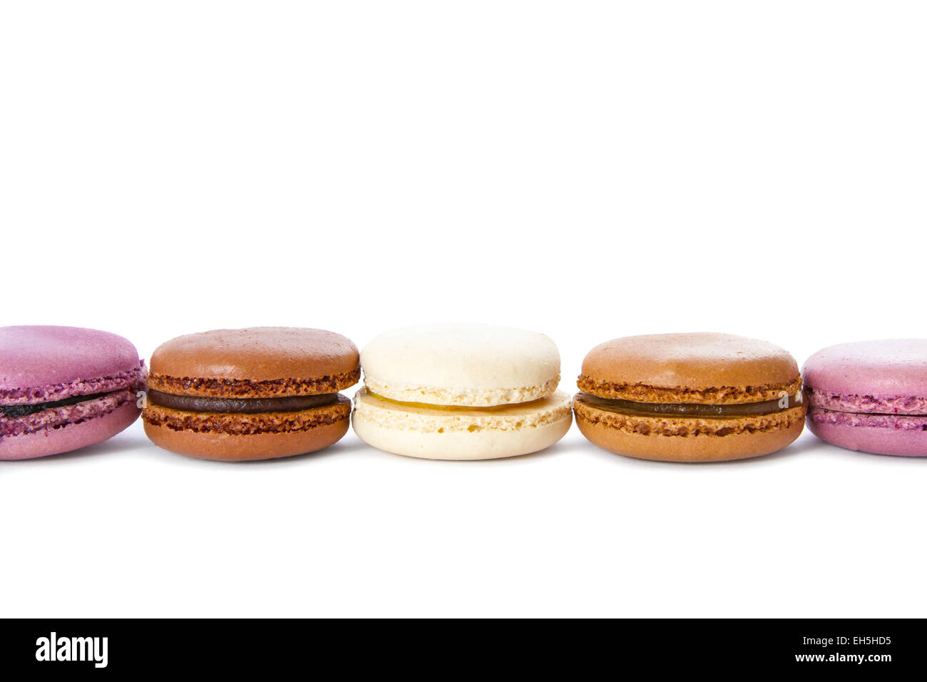 Doux, coloré et frais macarons français sur fond blanc. Vanille, chocolat et Cassis. Banque D'Images