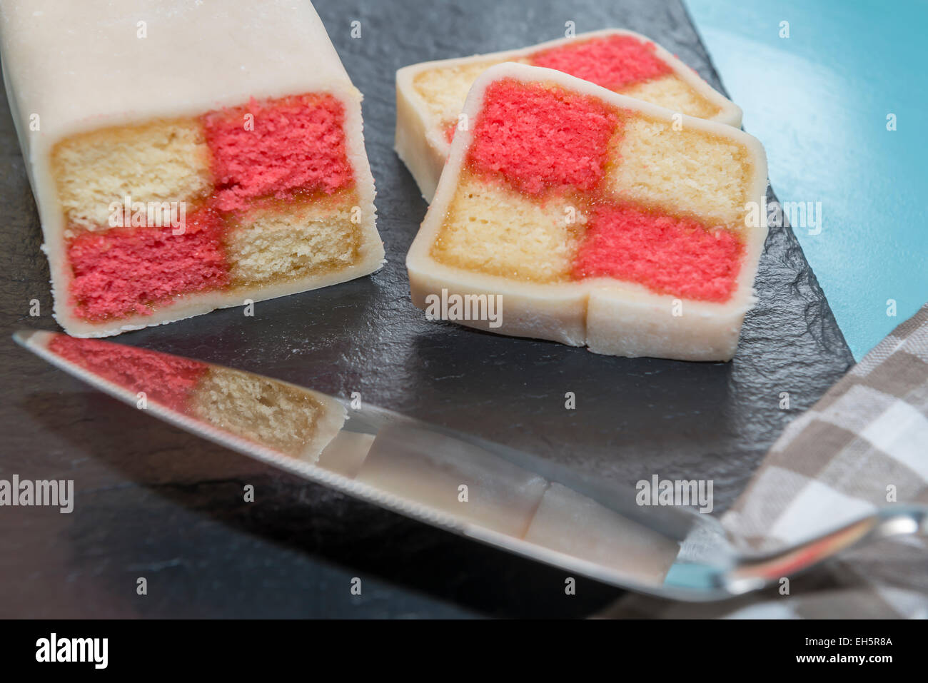 Libre de Battenberg cake reflète dans une tranche de gâteau au premier plan Banque D'Images