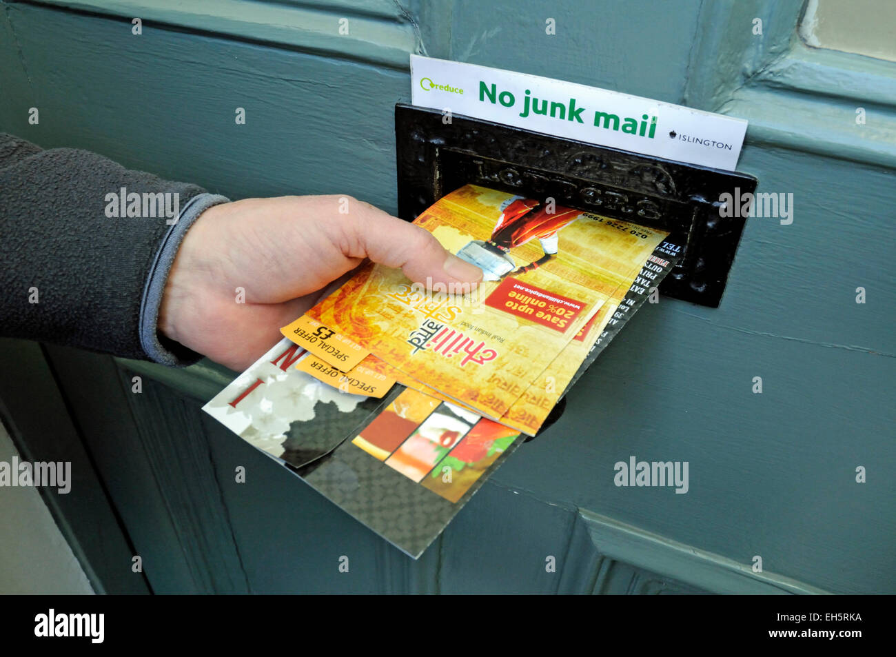 Mans part en poussant le courrier indésirable par lettebox avec aucun signe au-dessus de courrier indésirable, Département du Nord-Ouest de l'Angleterre, Royaume-Uni Banque D'Images