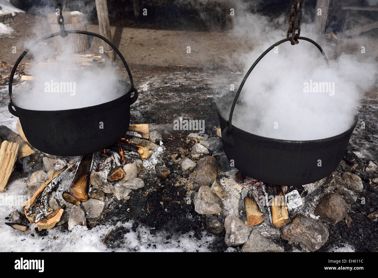 Méthode traditionnelle d'évaporer le sap dans deux pots en fonte sur feu de bois pour produire du sirop d'érable Canada Ontario Banque D'Images