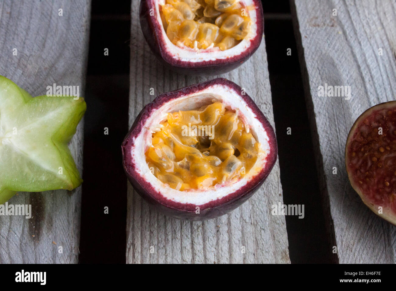 Les fruits de la Passion, près de carambole, de prune et d'un autre fruit de la passion, sur sol en bois Banque D'Images