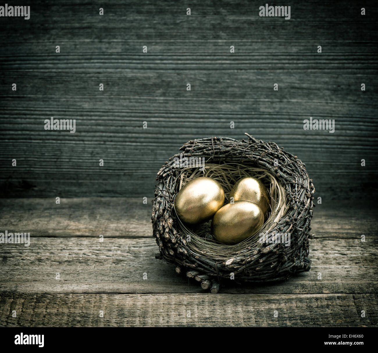 Oeufs de Pâques en nid d'or sur fond de bois rustique. Retro style tonique photo Banque D'Images