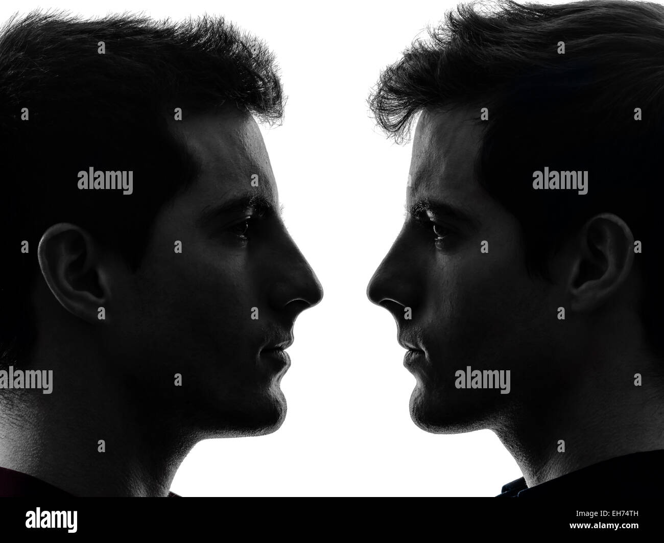 Portrait de deux jeunes hommes dans l'ombre fond blanc Banque D'Images