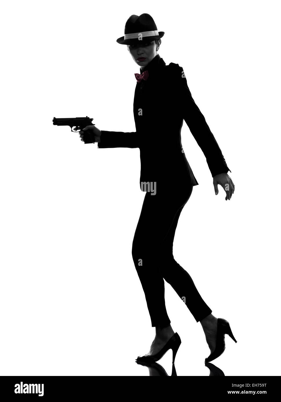 Une femme élégante in suit holding gun en silhouette sur fond blanc Banque D'Images