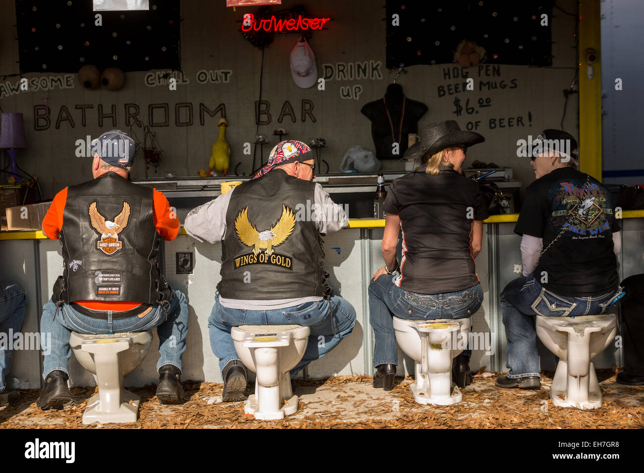 Les motards s'asseoir sur un siège de toilette à la salle de bains Stylo Porc bar pendant la 74e congrès annuel de la Daytona Bike Week 8 mars 2015 à Daytona Beach, en Floride. Plus de 500 000 motards et les spectateurs se rassemblent pour un événement au long de la semaine, le plus grand rallye moto en Amérique. Banque D'Images