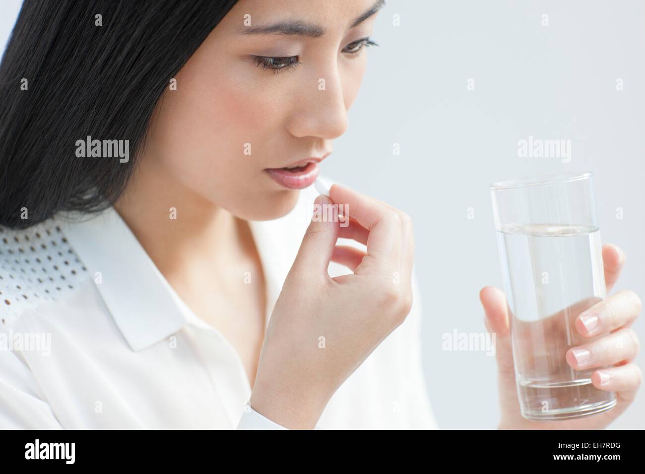 Woman taking painkiller Banque D'Images