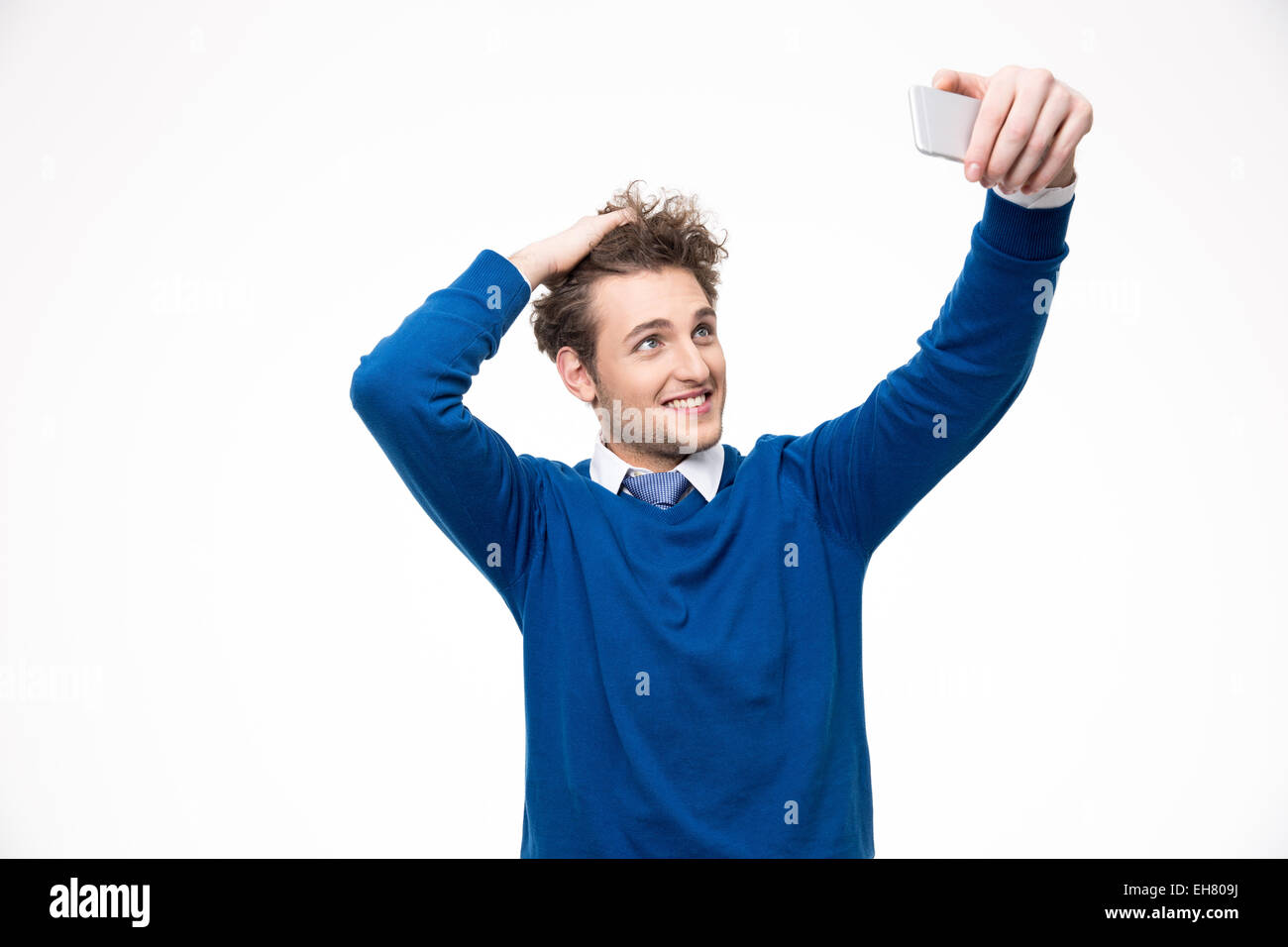 Homme heureux avec des cheveux bouclés avec le smartphone photo selfies Banque D'Images