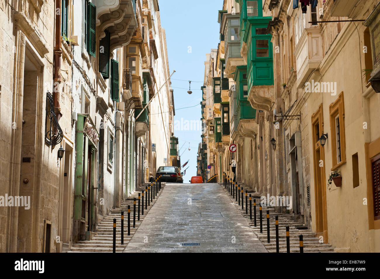 Rue typique, canyon urbain, route menant tout droit vers le centre historique, La Valette, Malte Banque D'Images