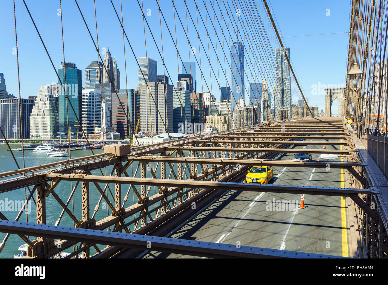 Yellow taxi cab crossing Brooklyn Bridge avec le Lower Manhattan skyline derrière, New York City, New York, USA Banque D'Images