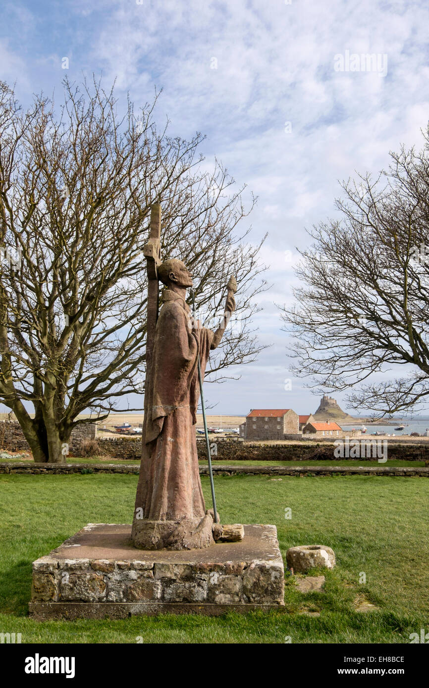 La statue de saint Aidan à Priory avec château de Lindisfarne dans la distance. L'Île Sainte, Northumberland, England, UK, Grande-Bretagne Banque D'Images