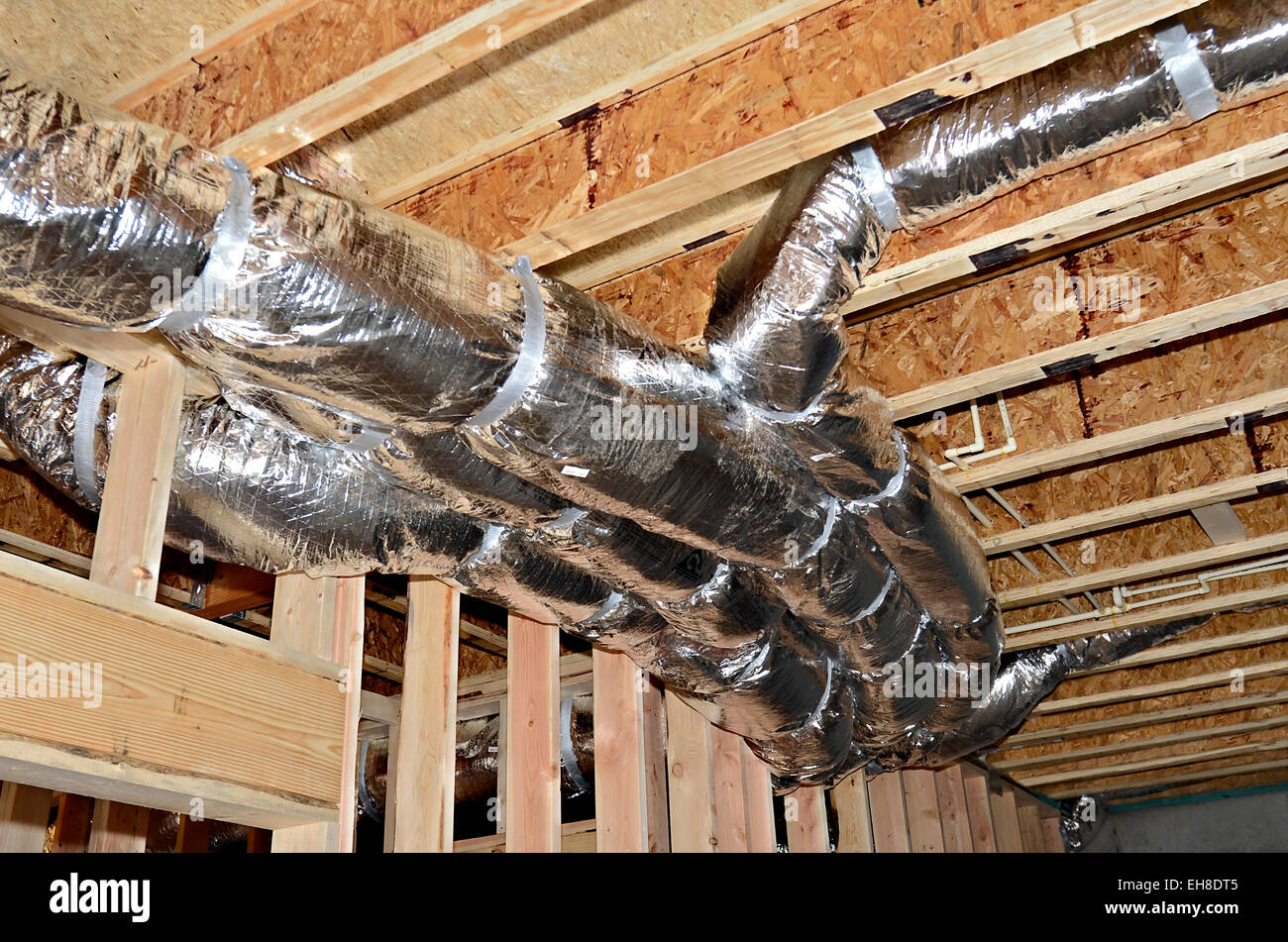 Un plafond de sous-sol dans une nouvelle construction montrant la chaleur/air conduit attaché au cadre et des tuyaux en PVC aussi. Banque D'Images