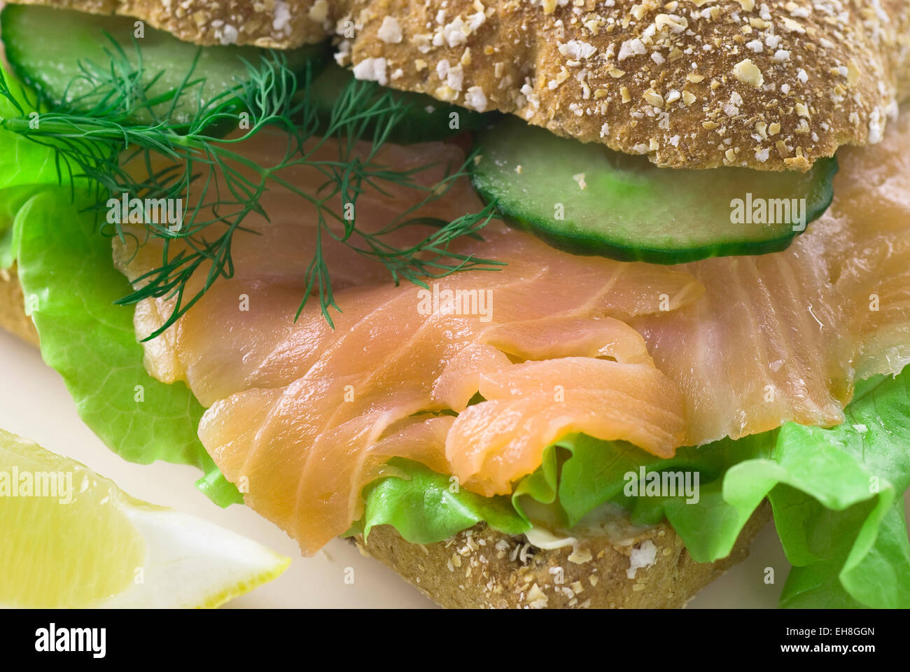 Tranches de saumon fumé avec salade verte, concombre et aneth frais dans du pain. Banque D'Images
