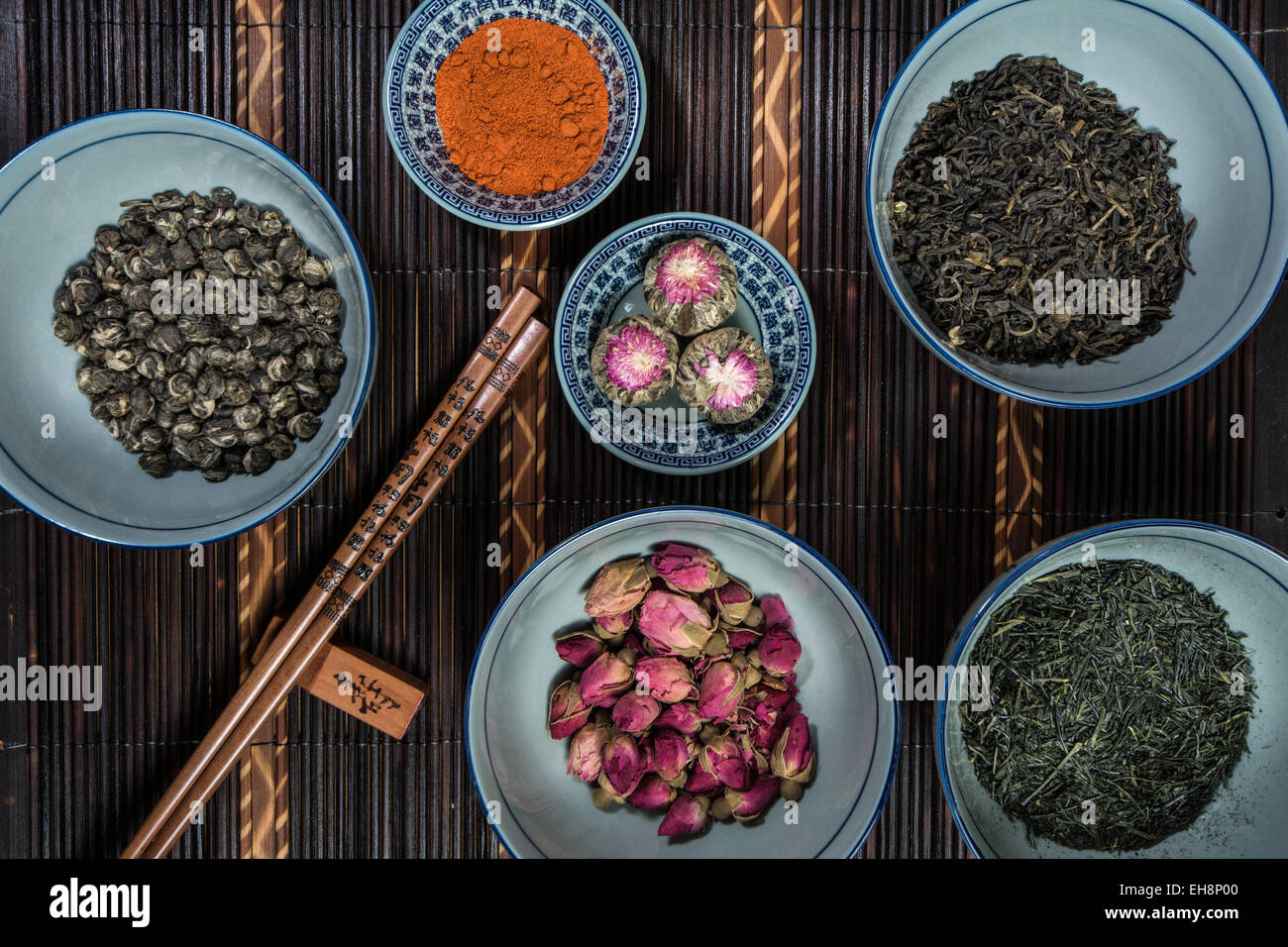 Chinese bols remplis de différentes sortes de thé décoré avec des baguettes Banque D'Images