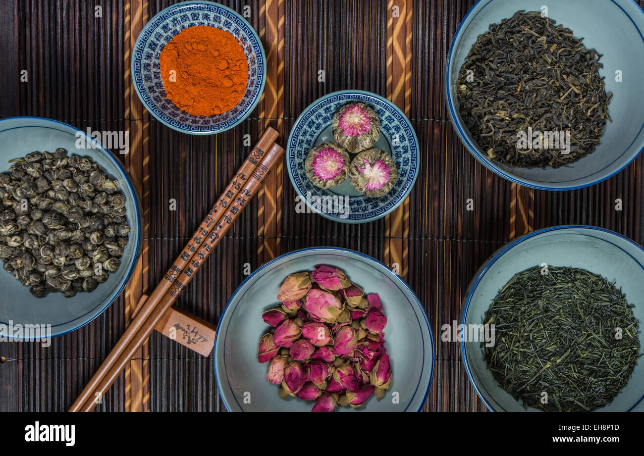 Chinese bols remplis de différentes sortes de thé décoré avec des baguettes Banque D'Images