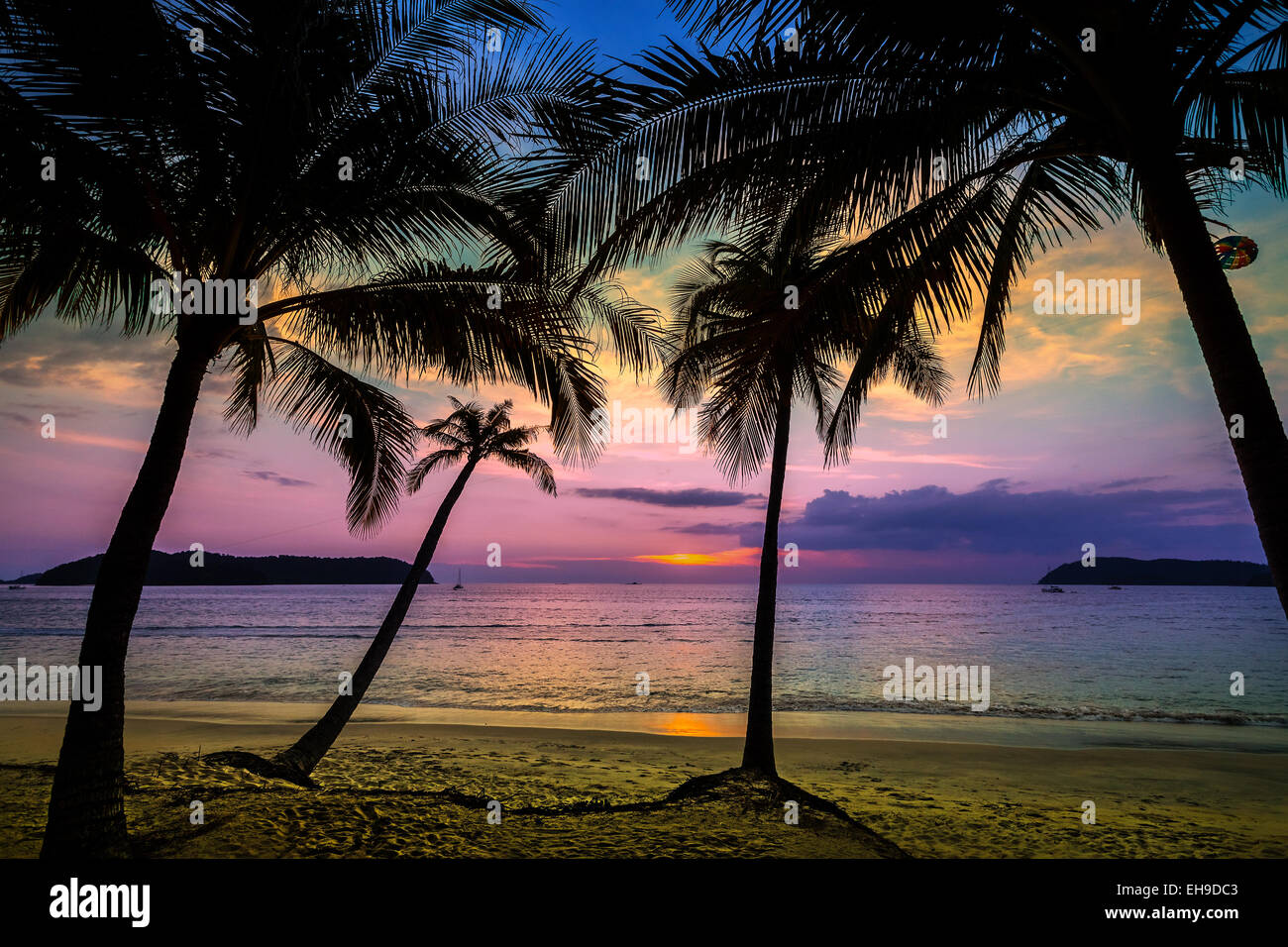 Maison de vacances historique faite de silhouettes de palmiers au coucher du soleil. Banque D'Images