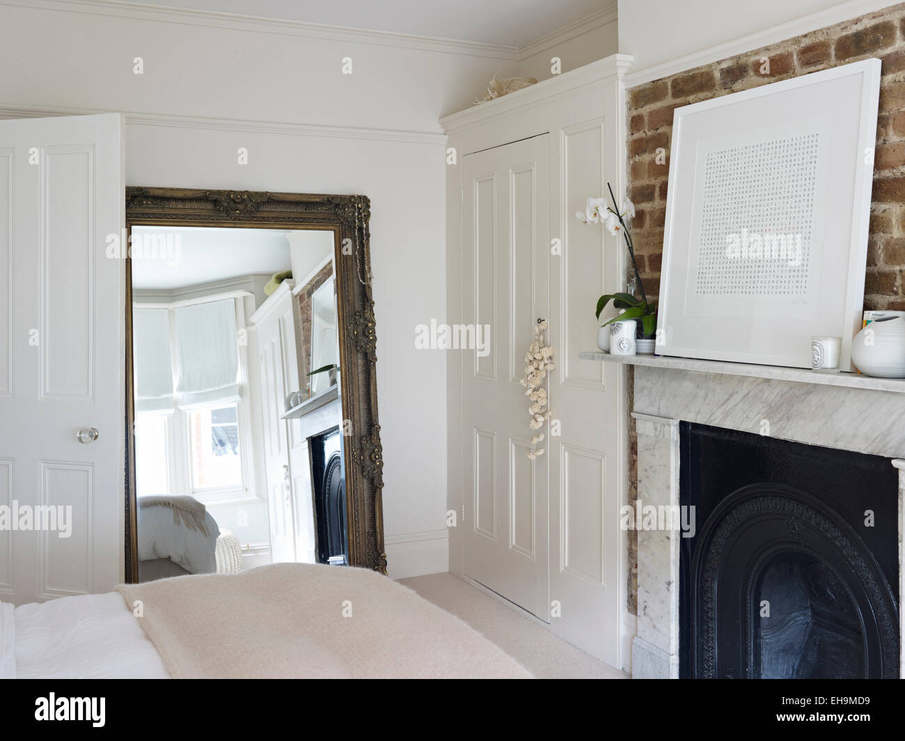 Chambre avec un grand miroir, placard lambris et cheminée en marbre noir avec firegrate, maison d'habitation, Port Hall Street, Brighton, East Sussex, UK Banque D'Images