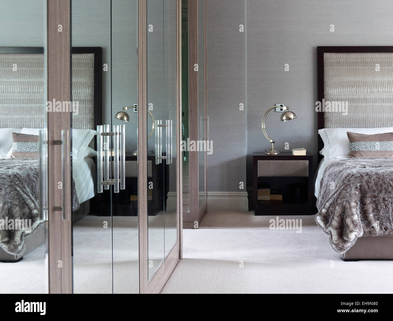 Lit avec grand lit et armoire avec miroir d'une réflexion à la lumière de  chambre à coucher moderne à Stevenage Road home, UK Photo Stock - Alamy