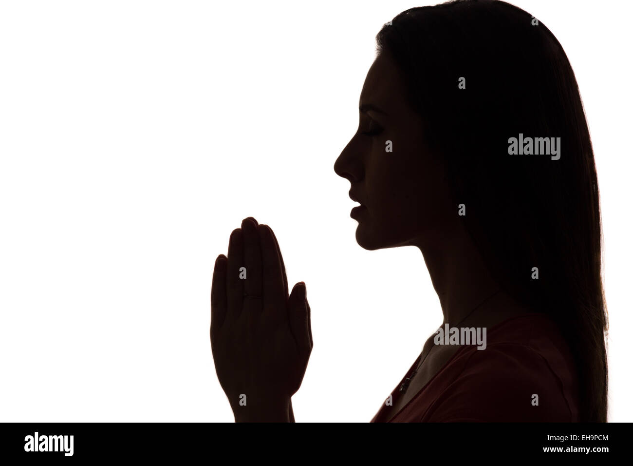 Profil gros plan d'une femme qui prie en silhouette isolated Banque D'Images